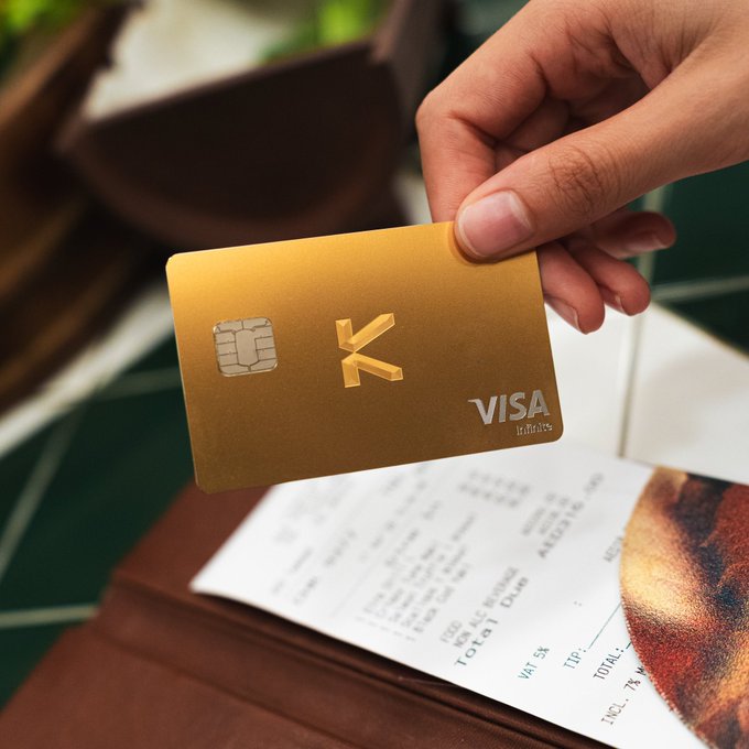 A hand holds a gold KAST Visa Infinite card above a restaurant receipt, illustrating the post's theme of stablecoins being used seamlessly for everyday purchases like dining out. The "VISA Infinite" and stylized "K" branding on the card ties directly to KAST's growing community sharing real-world crypto payment moments.