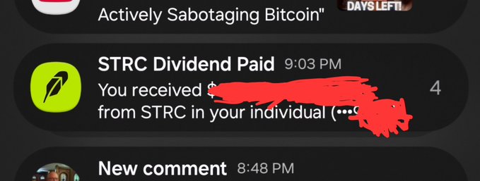 A screenshot of phone notifications showing an "STRC Dividend Paid" alert at 9:03 PM from Robinhood (green logo), with the dollar amount and account details scribbled out in red marker, seemingly mocking the successful dividend payment that skeptics had claimed would never happen.