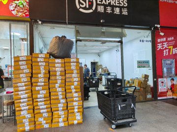 A storefront for SF Express is stacked high with packages, an image that visually represents the high volume of orders being shipped. The accompanying post is a call to action for those in specific regions to place batch orders for red envelopes, promising a significant bonus.