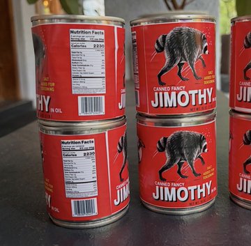 Several cans of "Canned Fancy Jimothy" featuring a blue-tick hound logo are stacked on a counter, with nutrition labels listing 230 calories per can and the quirky product pairing humorously with the joke about a dog named Jimothy approving of this unusual meat.