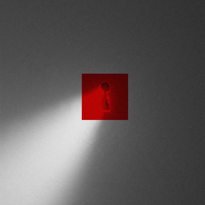 An abstract image showing a small red square with a keyhole shape illuminated against a gray gradient background.