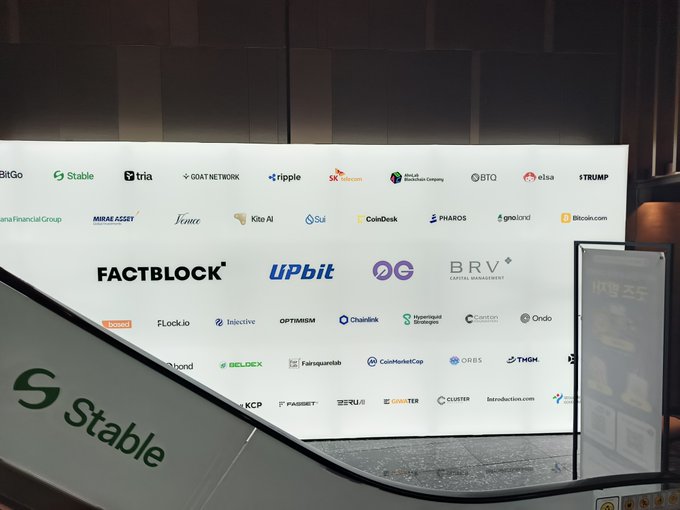 A sponsorship wall at a crypto/blockchain event features logos including 'FACTBLOCK', 'UPbit', 'BRV', 'CoinDesk', 'Phantom', and a prominent 'Stable' logo on the podium.