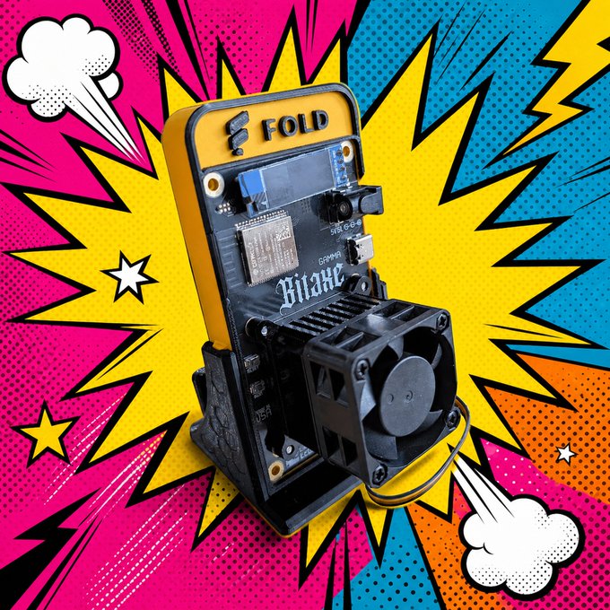 An electronic device labeled 'FOLD' and 'Bitaxe' shown against a pop-art comic burst background in pink, yellow, and blue.