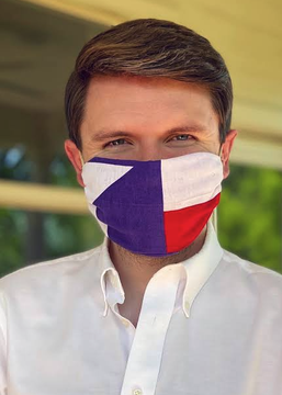 A young man in a white shirt and a flag-print face mask (resembling the Czech Republic flag) looks directly at the camera, with the image serving as a visual stand-in for James Talarico amid news of his rising 66% odds to flip the Texas Senate seat despite being sidelined from campaigning due to illness.