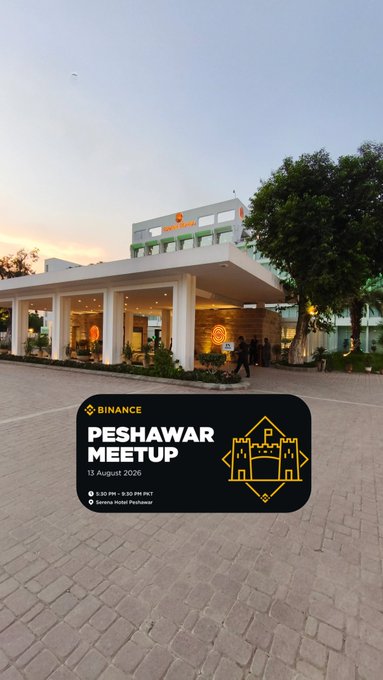 A promotional poster for a Binance Peshawar Meetup on 15 August 2026 at Serena Hotel Peshawar, displayed in front of the venue's exterior at dusk.