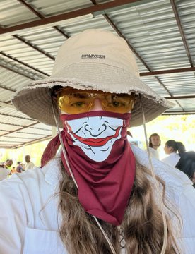 A woman wearing a wide-brimmed hat, yellow sunglasses, and a red Joker-themed face covering prepares to cheer on Spain, fitting the post's enthusiastic "VAMOS SPAIN" message tied to a trading competition with $4k in leaderboard prizes.