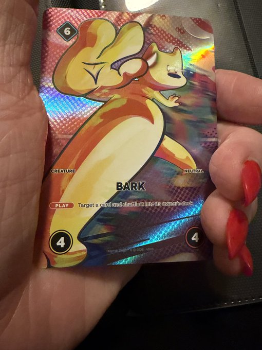 A hand with red nail polish holds a holographic Pokémon trading card labeled 'BARK', a Neutral Creature with 6 and 4 attack/health values.