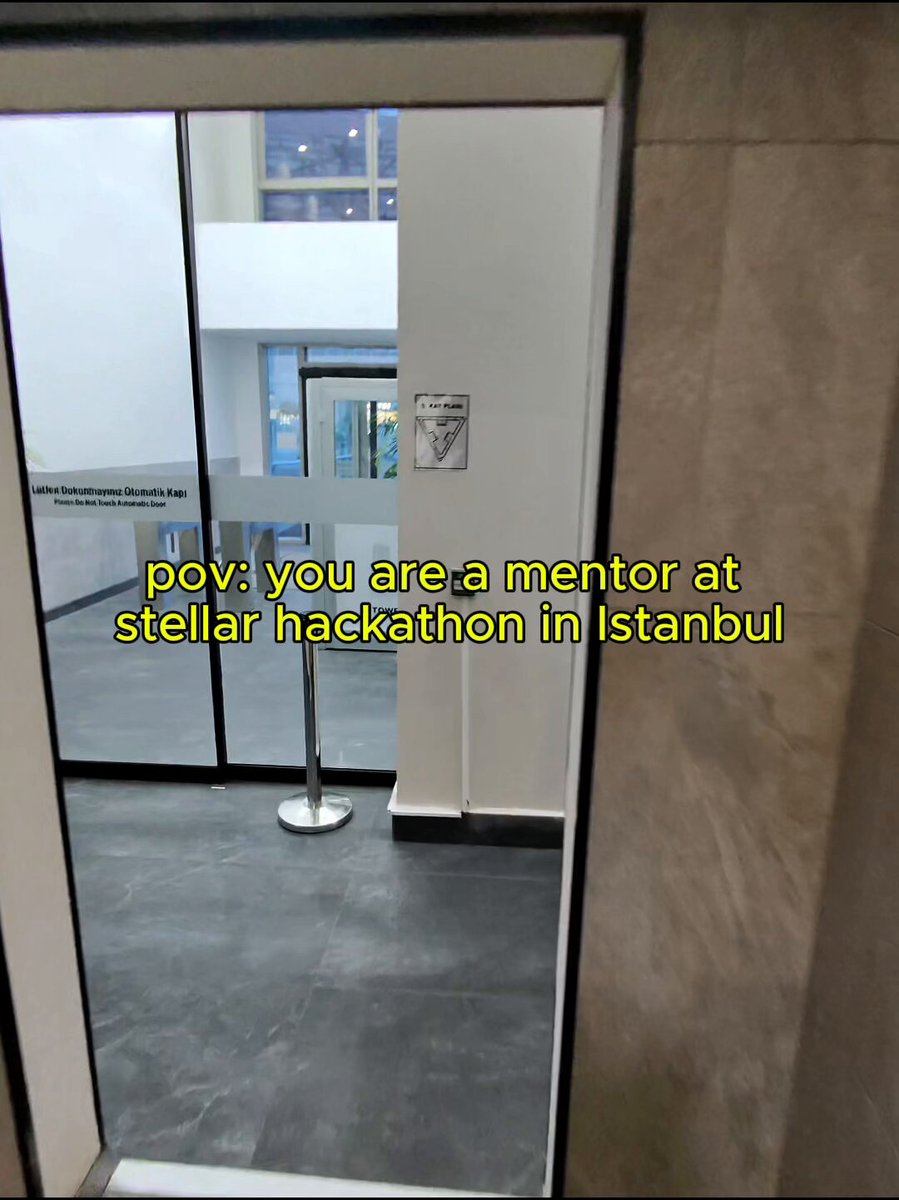 The image shows a mirror with text that reads "POV: you are a mentor at @StellarHackPera last year. Came back this year and felt the community growing stronger than ever. Same mission. More builders. Stronger momentum." The mirror is located in an office or workspace, as indicated by the presence of a desk and chair nearby.