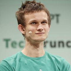 A young man with short brown hair wearing a green t-shirt and a headset microphone, appearing to speak at an event with "TechCrunch" partially visible in the background.