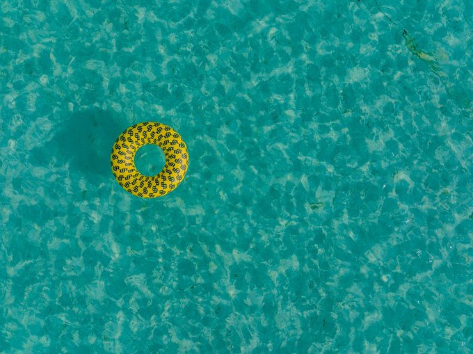 A yellow inflatable swim ring floats alone in a clear turquoise pool, evoking a quiet, slow-paced Sunday with little activity—much like thin weekend trading volumes that leave markets in a similarly calm, idle state.