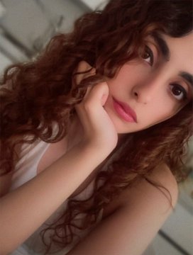The image features a woman with long brown hair wearing a white tank top. She has her hand resting on her cheek and looks at the camera directly. The caption of the image reads "Good Morning I give up my peace. 1/1, 0.35 eth". This means that she is giving up her peace for the photo to be taken.