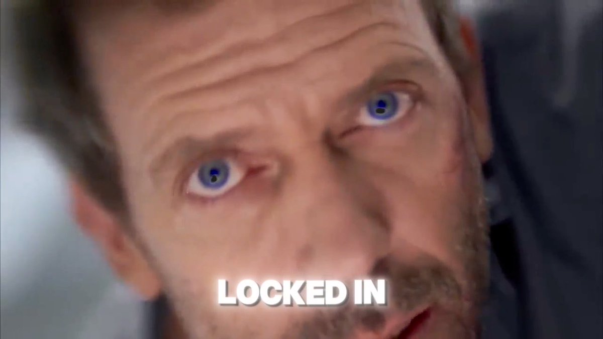 A close-up of a man's face with wide, intense eyes and the text 'LOCKED IN' displayed at the bottom in white capital letters.