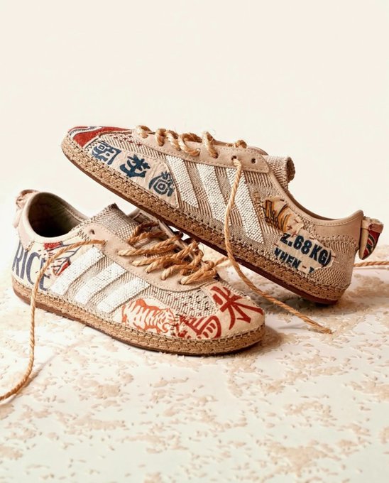 A pair of handcrafted Adidas Superstar sneakers featuring woven textile uppers, espadrille-style jute midsoles, and red Asian calligraphy details rests on a terrazzo surface, with visible text including "Z.BBKG" and "XWEN" on the heel.