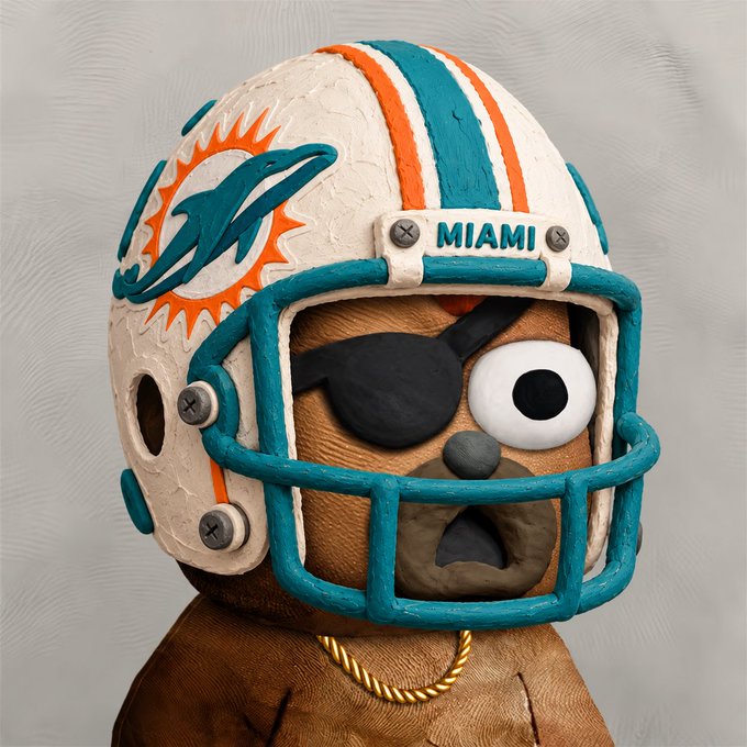 A handcrafted clay sculpture of a brown bear wearing a Miami Dolphins NFL helmet with an eye patch and gold chain necklace.