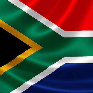 The image displays the waving flag of South Africa, featuring its distinctive green Y-shape bordered in white and yellow, with red at the top and blue at the bottom. The post relates to a South African policy proposal to regulate offshore cryptocurrency transfers through licensed platforms under central bank oversight.