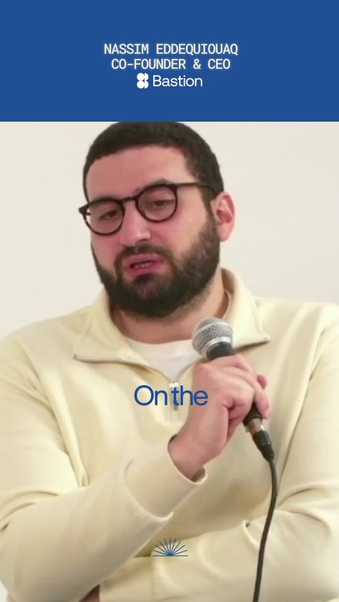 The image shows a man wearing glasses and a white shirt holding a microphone while talking into it. The caption reads "Onthe" above his head, which suggests he might be speaking at an event or addressing a specific topic related to the content of the image.