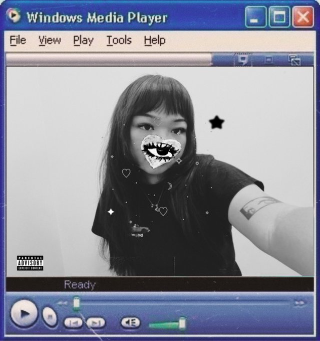 A stylized image mimicking the Windows Media Player interface, showing a black-and-white selfie of a woman with an eye-heart filter over her face, labeled "PARENTAL ADVISORY EXPLICIT CONTENT" and status "Ready".
