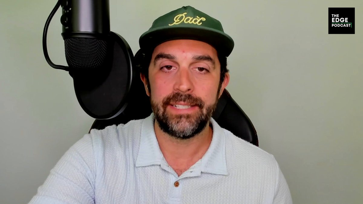 The image features a man wearing a green baseball cap with the word "DAD" written on it, sitting behind a microphone. The background appears to be a white wall or a gray surface. There are also some text elements present in the image that read "New @Edge_Pod is out! In market corrections like this, we continue our search for DeFi tokens backed by real revenue, clear value accrual, and healthy cashflows." Additionally, there's an email address written below the man with a microphone.