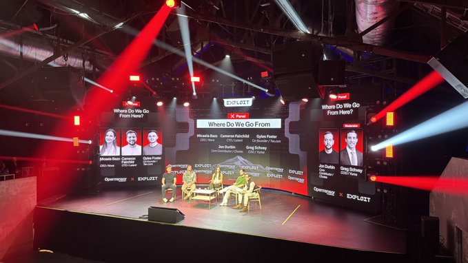 Conference panel called 'Where Do We Go From Here?' at an Openware x Exploit event, featuring speakers Riccardo Basso (CMC Hass), Cameron Fairchild (GGX Nova), Dylan Foster (CypherHunter), Joe Dundon (UpOnly), and Greg Solano (Yuga Labs).