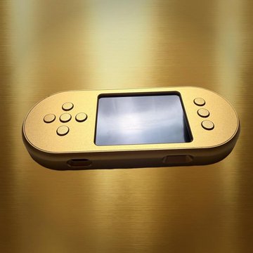 A gold handheld gaming device with a screen and control buttons resting on a reflective gold surface.