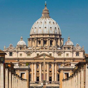 St. Peter's Basilica, the world's largest Christian church located in Vatican City, stands beneath a clear blue sky as Vatican-affiliated media praises Bitcoin as a "store of value comparable to gold," emphasizing its scarcity and resilience against unlimited fiat currency printing by central banks.