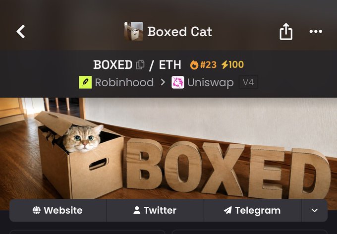A cat peers out of a cardboard box next to large cardboard letters spelling "BOXED," displayed on a trading interface for the $BOXED token on Robinhood/Uniswap (rank #23, ETH, V4). The image directly visualizes the token's name and playful concept, reinforcing the post's call to join the "BOXED" cult and buy in before missing the next meme trend.