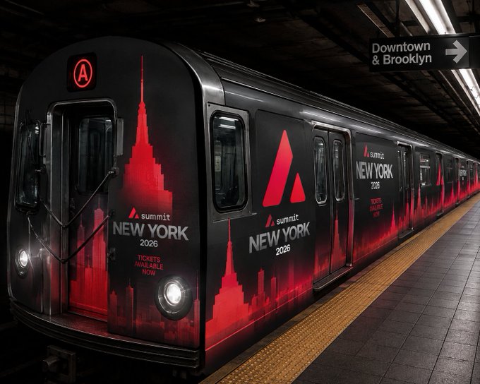 A New York City subway train wrapped in red and black advertising for "summit NEW YORK 2026" with "TICKETS AVAILABLE NOW," parked at a platform with a "Downtown & Brooklyn" sign overhead.
