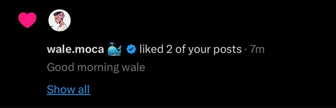 The image shows a social media post from Wale Mocca, who has tagged his friend with a heart. The post includes a message that reads "Good morning wale! I liked 2 of your posts 7m". The caption also mentions that there is an interesting photo in the image and asks if the person wants to see it.