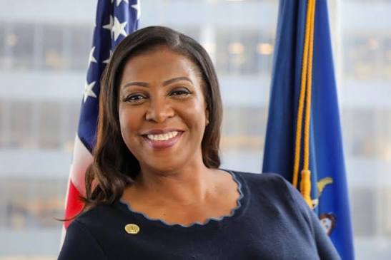 A professional portrait of New York Attorney General Letitia James, smiling in front of an American flag and what appears to be the New York State flag, accompanying news that she is leading a bipartisan coalition of state attorneys general in urging Congress to reject the CLARITY Act over concerns it could undermine state authority to protect investors from fraud.
