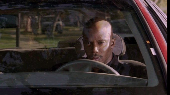 A man with a serious expression sits behind the steering wheel of a car, looking intently through the windshield. The intense gaze could reflect the competitive tension implied by the post about "fomo making their own launchpad," suggesting someone poised to navigate the high-stakes world of new ventures.