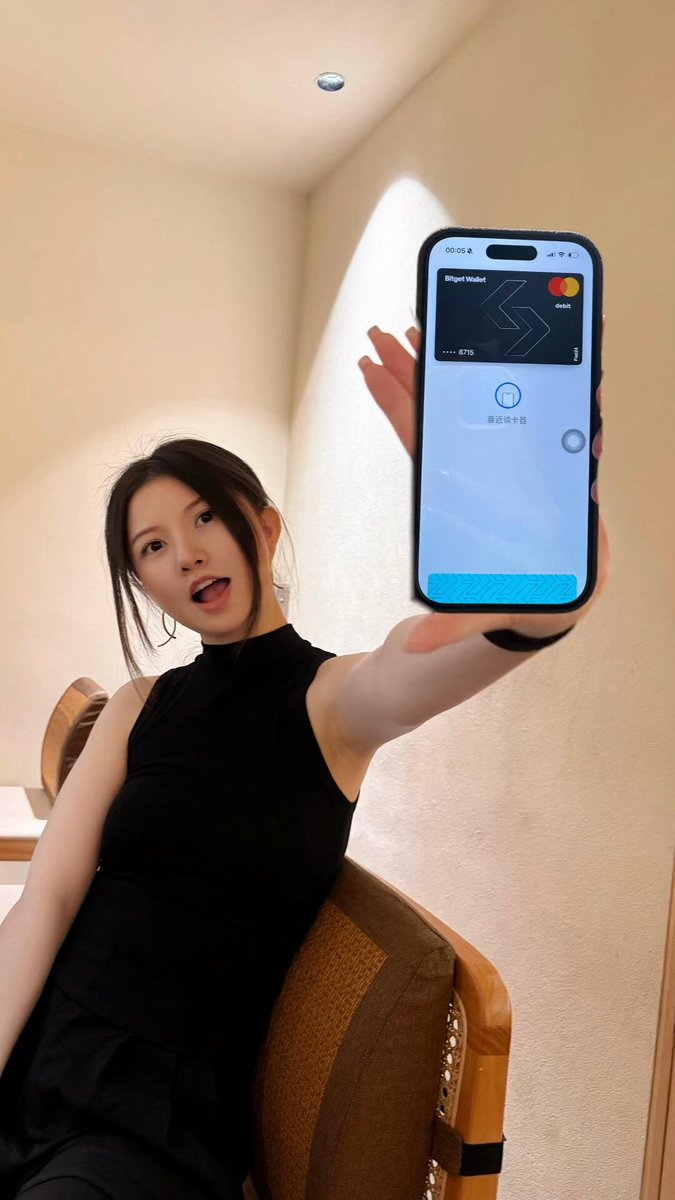 The image features a woman sitting down, holding up her cell phone with an app displayed on its screen. The app appears to be related to cryptocurrency or digital currency, as indicated by the text "Crypto Survival Plan" written below the app icon. This suggests that she might be exploring ways to use Bitcoin or other cryptocurrencies for financial transactions and investments.