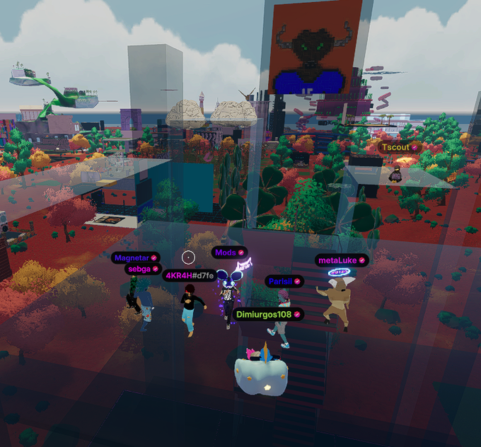 A screenshot from a virtual 3D world showing multiple avatar users with name tags including 'Magnetar', 'sebga', '4KRAHH#07fc', 'Mods', 'metaLuke', 'Pariasi', 'Dimiurgos108', and 'Tscout', gathered in a colorful, blocky landscape with a bull head design on a wall.