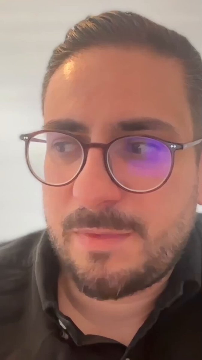 The image features a man wearing glasses, with his face partially visible behind them. The man appears to be looking directly at the camera, possibly posing for a photo or video. The background of the image is white, which contrasts with the dark tones of the man's face and glasses. There are no texts present in the image, but there is a caption that reads "@RealMissAI of the @dealflowpodcast speaks to @peaq CBO @MartinElKhouri about the three possible outcomes from the age of the machine economy...".