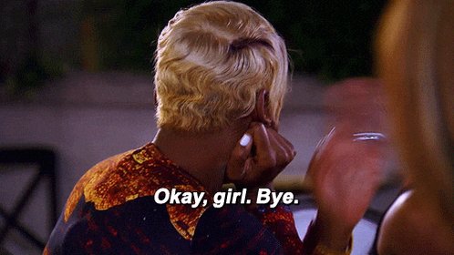 The image features a person with blonde hair wearing an orange shirt, sitting at a table or counter while talking on their cell phone. The text "okay girl, bye" can be seen written above them. In the background, there are chairs and a dining table visible in the scene.