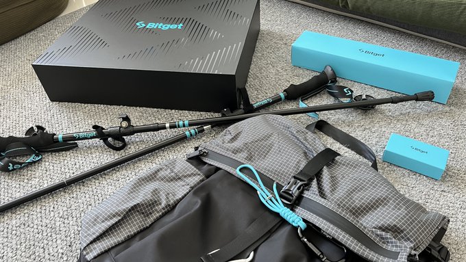 An unboxed set of golf equipment from the brand "sri get" laid out on a carpet, including a black box, golf clubs with teal accents, a small blue box, and a gray plaid golf bag.