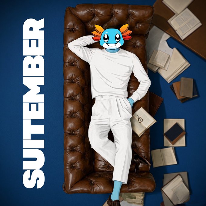 A character with a blue axolotl-like head lounges on a brown tufted leather sofa in white clothing, surrounded by scattered books, with the word 'SUITEMBER' displayed vertically in bold white text.