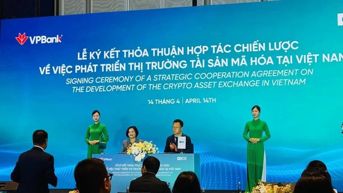 VPBank signing ceremony for a strategic cooperation agreement on developing a crypto asset exchange in Vietnam, dated April 14th, with officials seated at a table flanked by women in green áo dài.