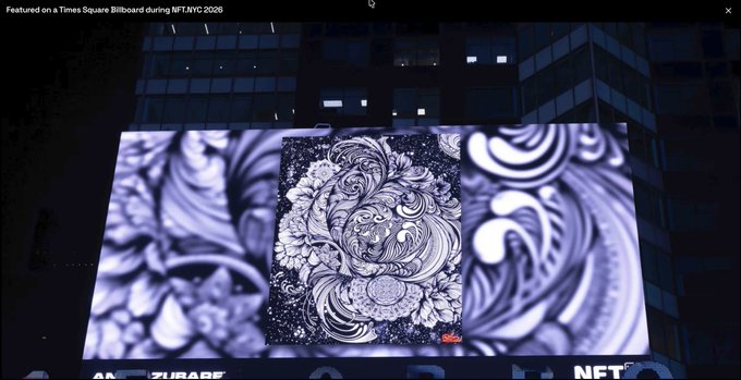 A Times Square billboard in NYC displays an intricate black and white swirling ornamental artwork, with text noting it was 'Featured on a Times Square Billboard during NFT.NYC 2026'.