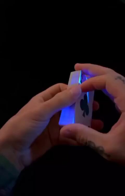 The image shows a person's hands holding a small white card with a blue light on it, which appears to be glowing or emitting a blue light. The card has a design of a four-leaf clover on it. The background is black, making the card stand out even more. The post seems to be promoting a political campaign or event related to Trump and the United States.