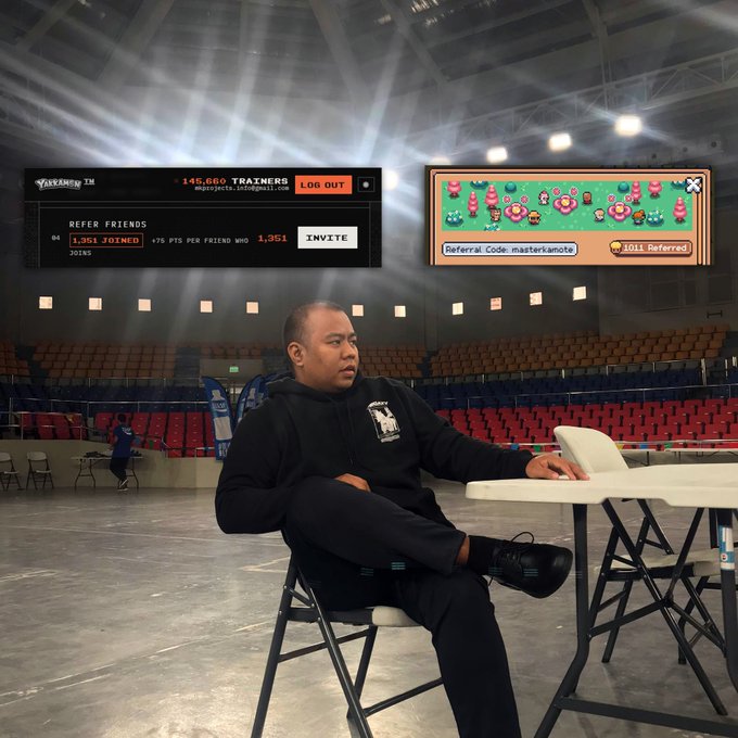 A man in a black hoodie sits at a folding table in an empty arena, with overlays showing "145,660 TRAINERS", "REFER FRIENDS" stats, "Referral Code: masterkamote", and "2,011 Referred".