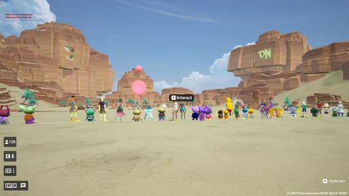 A screenshot from a video game showing various cartoonish avatars and characters gathered in a desert canyon environment with a "K Interact" prompt, pink balloons floating, and a UI showing "120", "4", "32", and "ENTER P".