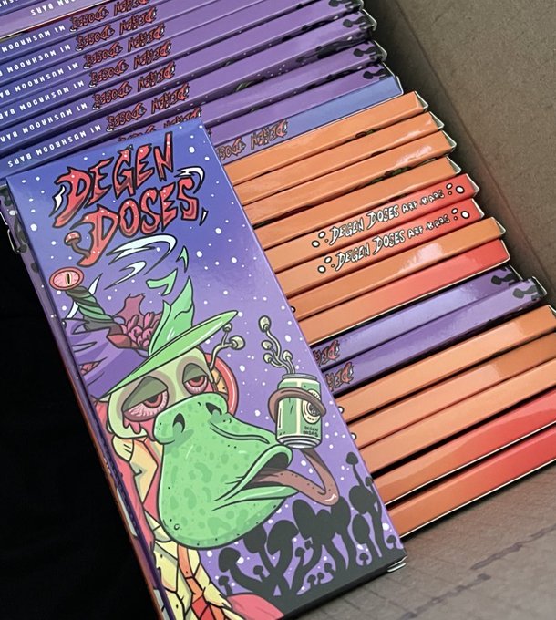A box of colorful "Degen Doses" CBD chocolate bars sits in a cardboard shipping container, featuring psychedelic artwork of a green dragon-like creature wearing a hat and smoking, with visible product text including "Sour Moonbeam" flavors. The image ties to the post's promotion of @degendoses, showcasing their vibrant, cannabis-inspired bar packaging.