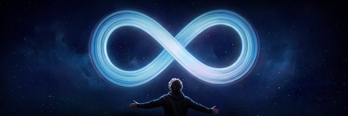 A man with his arms outstretched facing a glowing, luminous infinity symbol set against a starry night sky background.