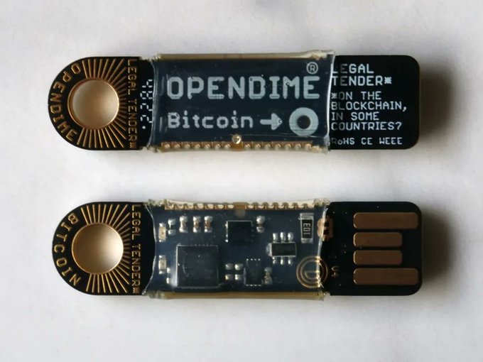 Two Opendime Bitcoin USB drives shown from front and back, with the front displaying "OPENDIME Bitcoin" and "LEGAL TENDER" markings.