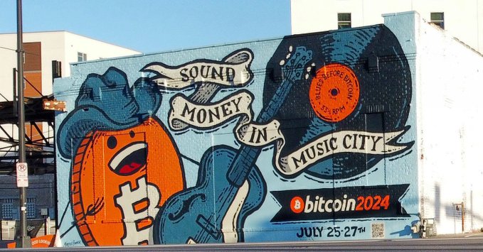 A colorful street mural on a building wall advertising 'bitcoin2024' with text 'SOUND MONEY IN MUSIC CITY' and 'JULY 25-27TH', featuring a character wearing a cowboy hat.