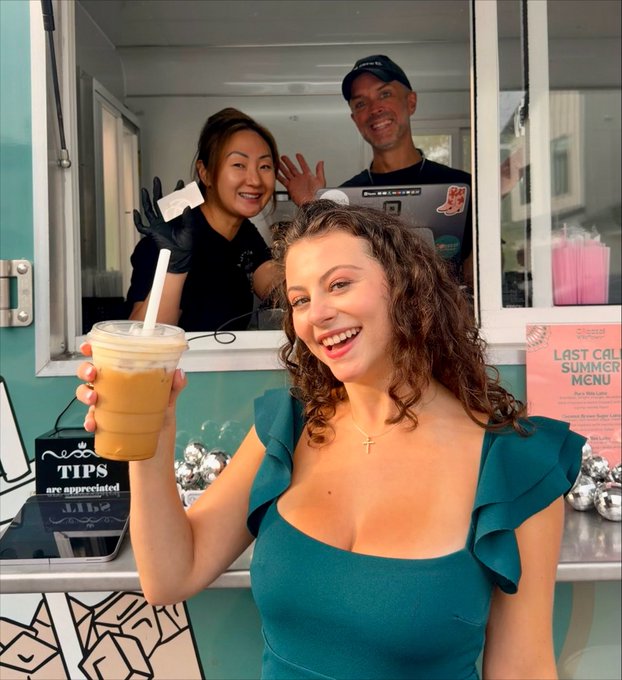A woman with curly hair stands in front of a turquoise food truck, smiling while holding up an iced coffee, as two baristas wave from the service window. Visible text includes a "TIPS are appreciated" sign and a pink flyer advertising "Last Call Summer Menu" — tying the post's theme of rewarding local coffee purchases with XRP cashback via the Uphold debit card.