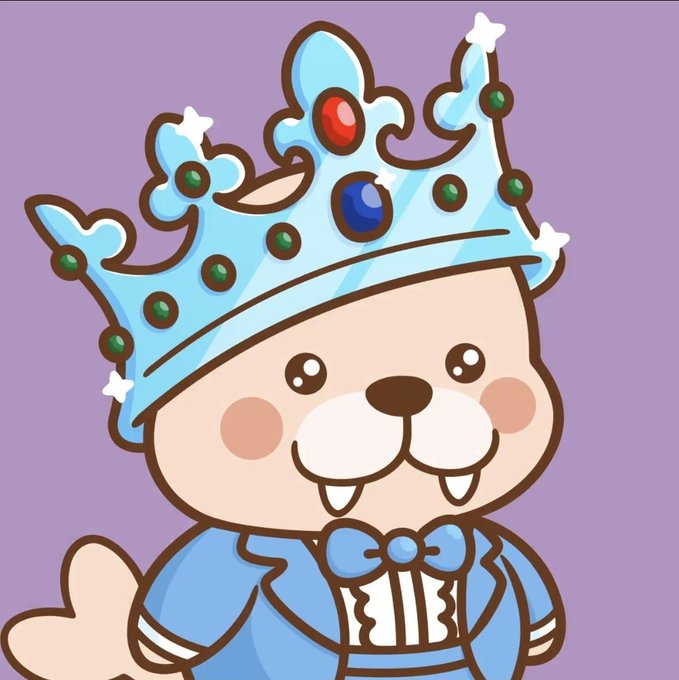 A cute cartoon character, possibly a bear or bunny, wears a blue jeweled crown and a blue suit with a bow tie on a purple background.