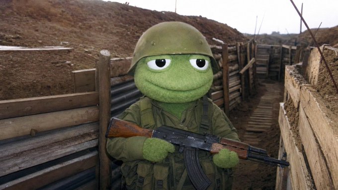 A digitally edited image of Kermit the Frog dressed as a soldier in a trench, holding an AK-47.