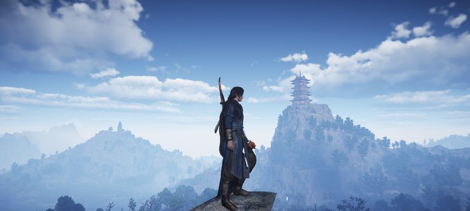 A character with a sword on their back stands on a rocky cliff overlooking a misty, mountainous landscape with a pagoda perched on a distant peak.