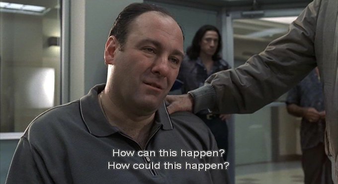 A cinematic still showing actor James Gandolfini as Tony Soprano with subtitles reading 'How can this happen? How could this happen?' while another character's hand rests on his shoulder.